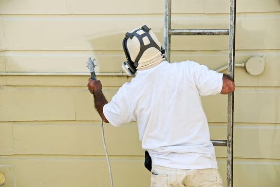 man starting on exterior painting